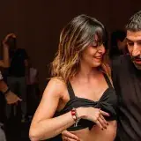 Une soirée Villa Vida : une danseuse sourit, son partenaire guide, lumière violette au fond.